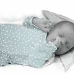 Een baby slaapt met duimpje in zijn mond.