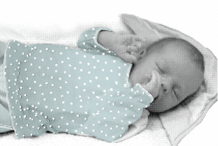 Een baby slaapt met duimpje in zijn mond.