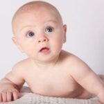 Een baby kijkt verbaasd.