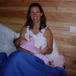 Moeder met een koffie en de baby drinkt bij haar. Dit is een echte foto, van mij met mijn dochter.